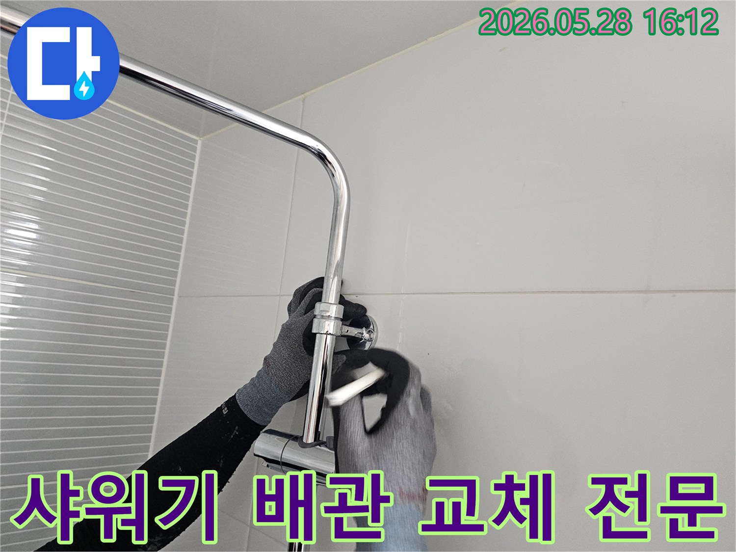 숙련된 작업자가 장갑을 착용하고-다산동 빌라 화장실의 샤워기 배관을 전문적으로 교체하고 있습니다.