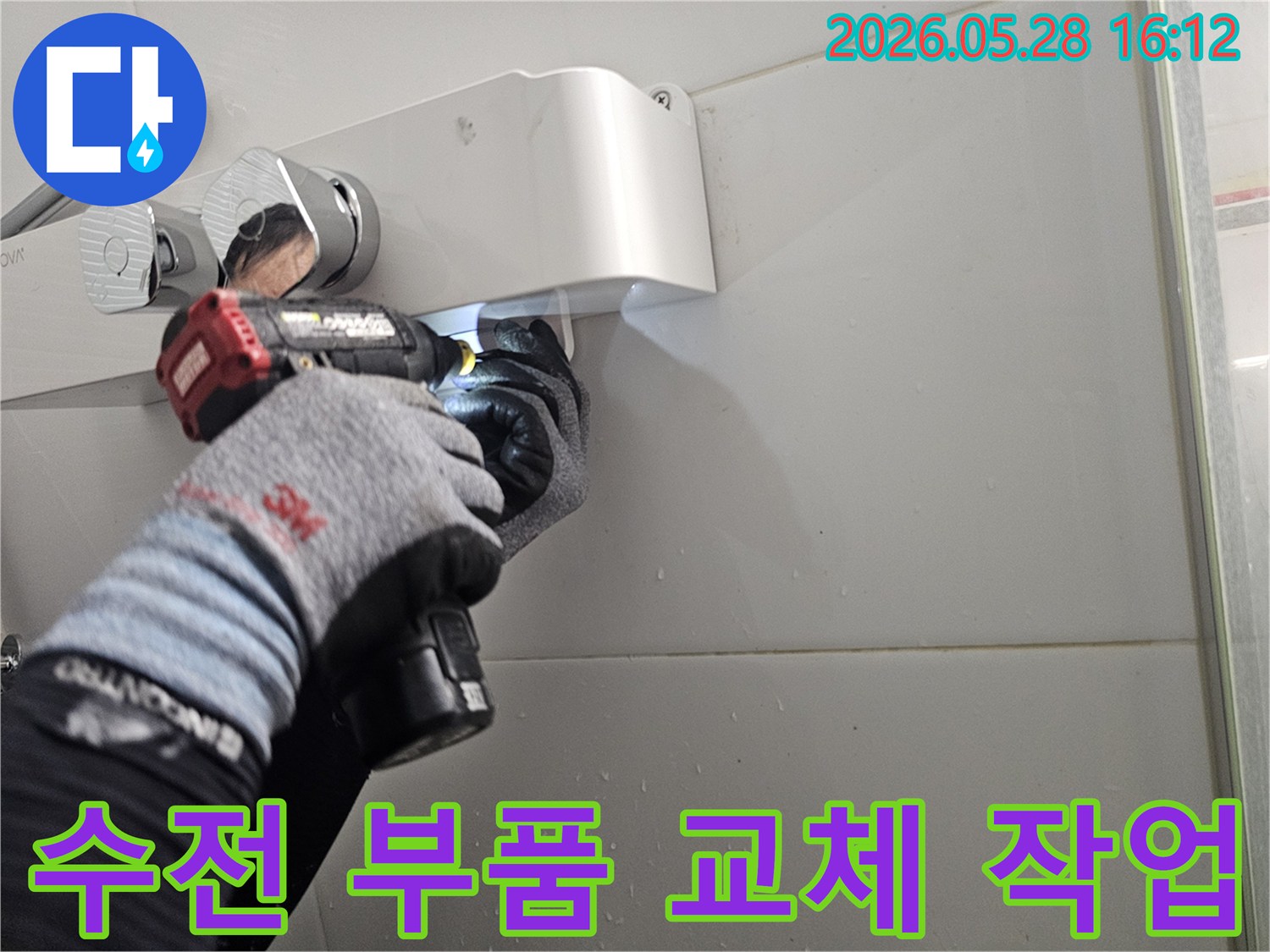전문 기술자가-보호 장갑을 착용하고-전동 공구로-샤워기 수전의-손상된 부품을-새것으로-교체하는-모습입니다