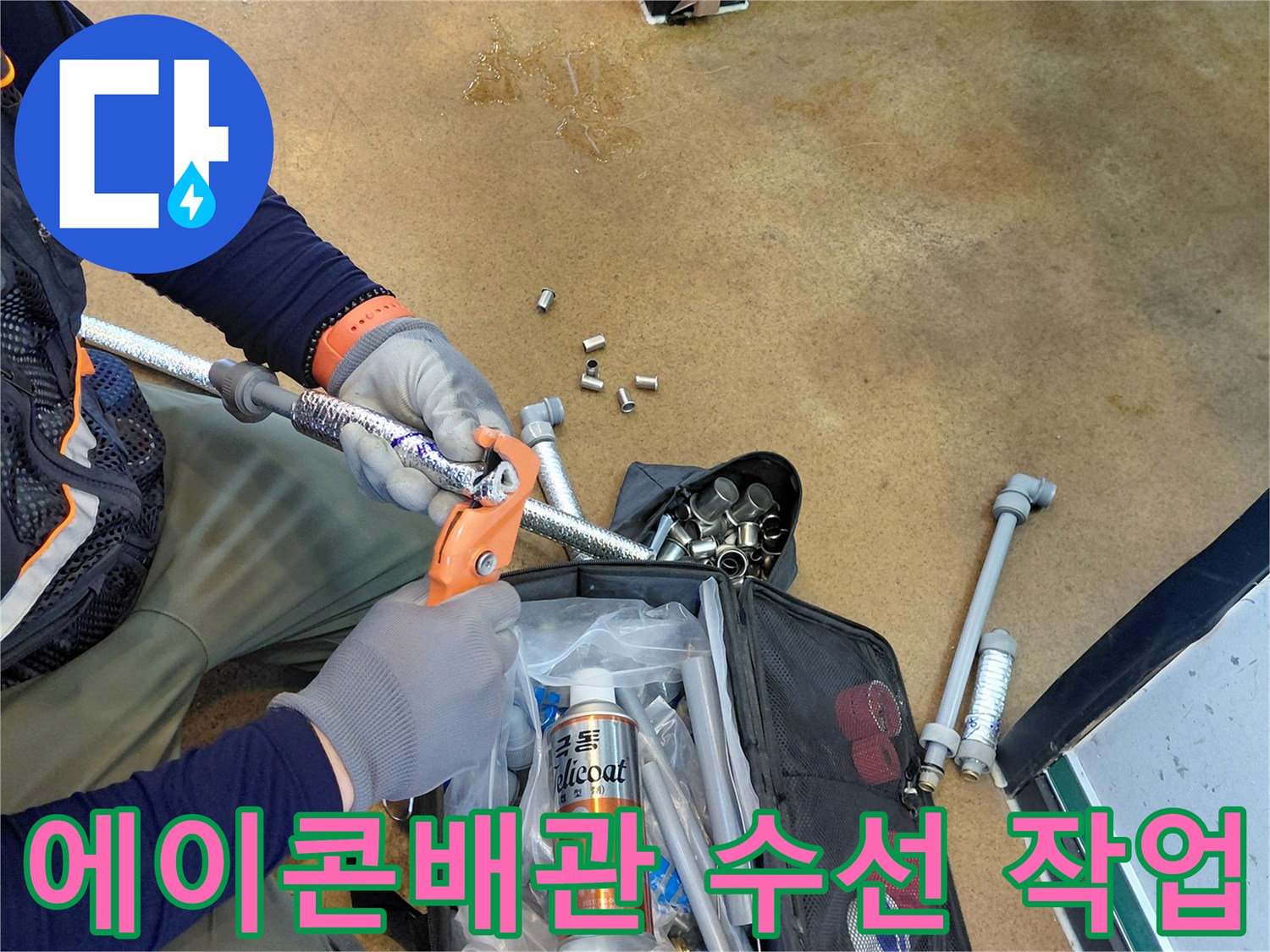 싱크대 아래 에이콘-배관 연결 부위를 정밀하게 조이는 작업 모습