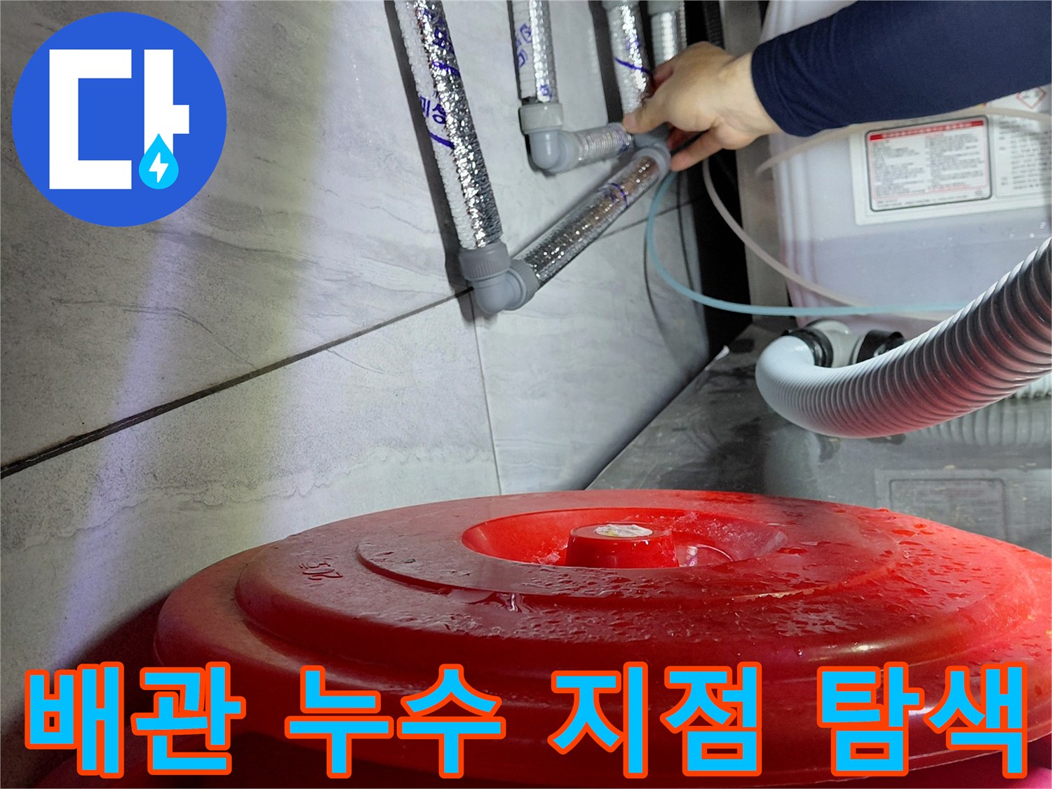 좁은 싱크대 하부 공간에서 배관 연결 상태를 점검하는 작업 모습