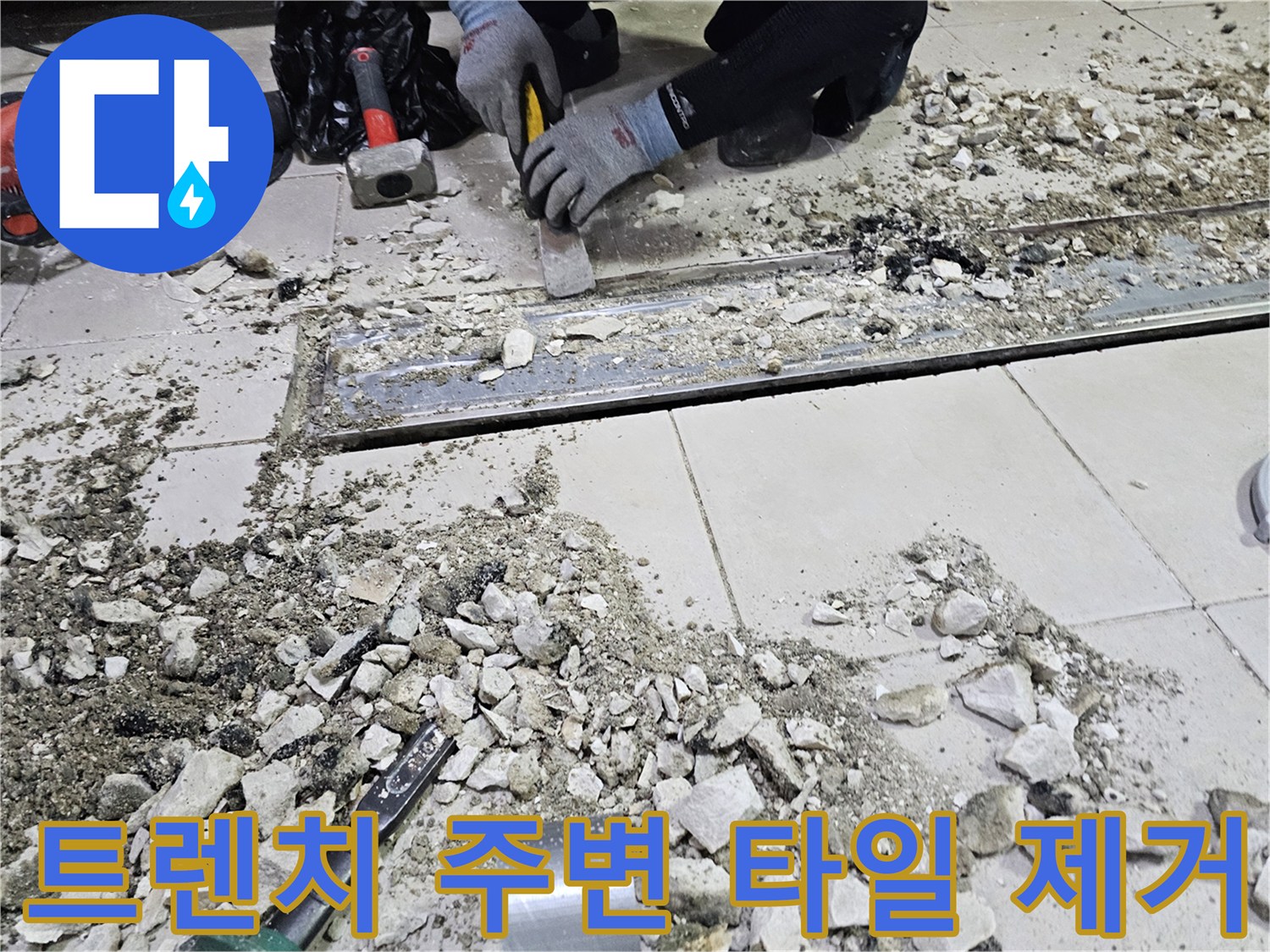 식당 주방의 배수 트렌치 부근 누수를 잡기 위해 타일을 파쇄하고 있는 모습입니다.