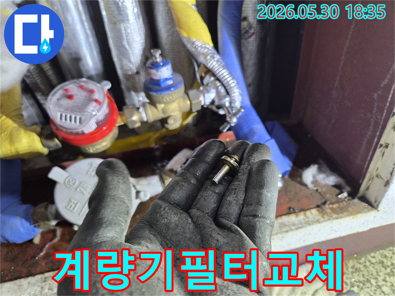 수도-계량기-내부-필터-부품을-작업자가-교체하기-위해-들고-있는-장면