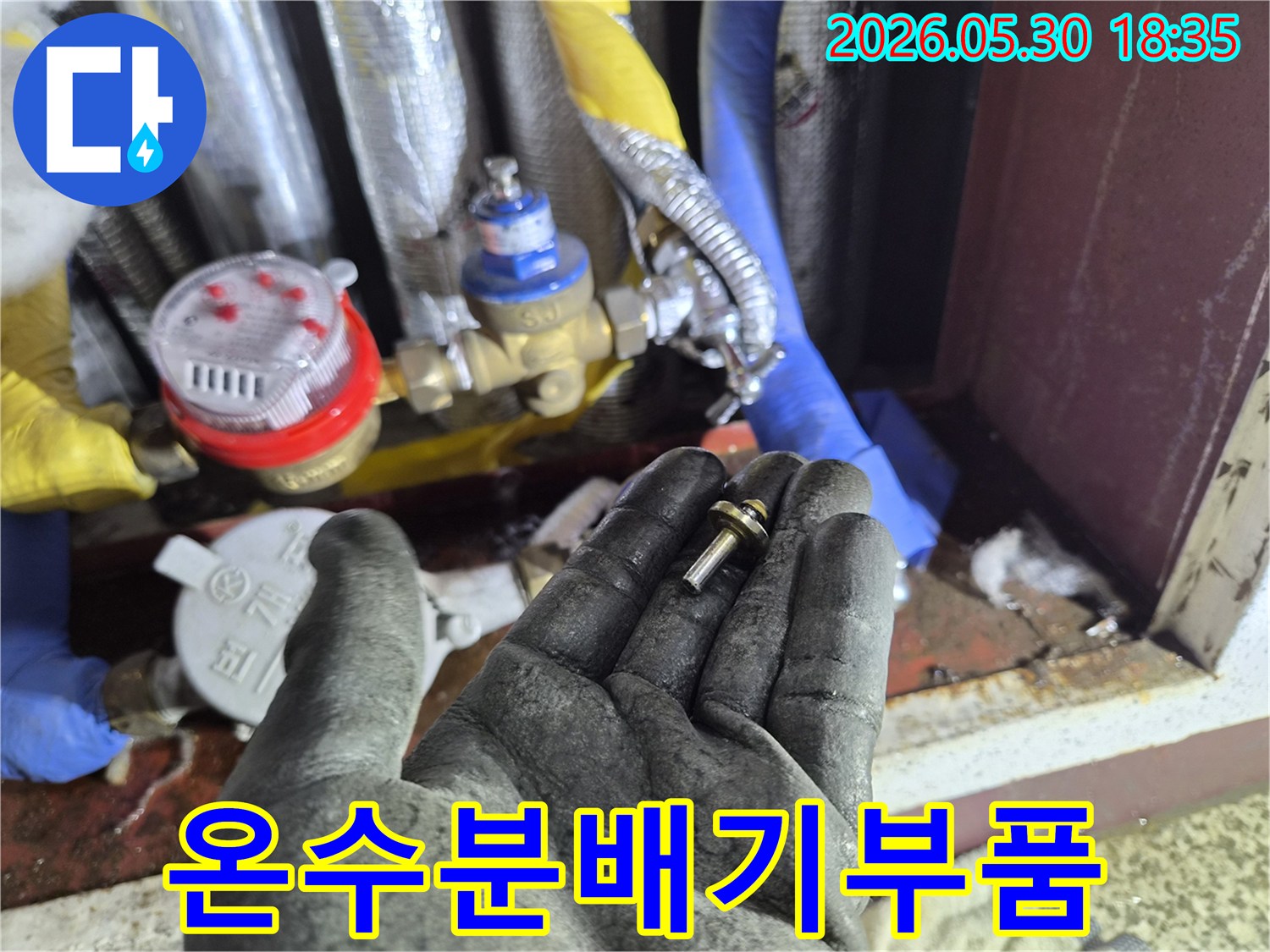 주택-온수분배기-누수-현장에서-발견된-손상된-부품을-작업자가-확인하는-모습