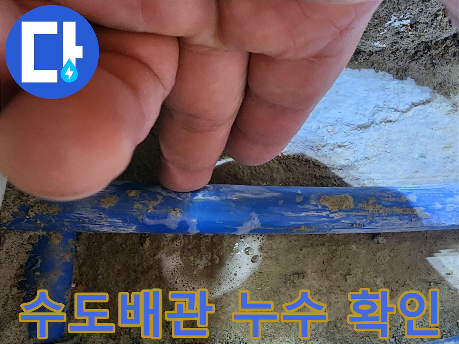 손가락으로 가리키는-파란색 수도관에서-거품이 발생하는-누수 지점