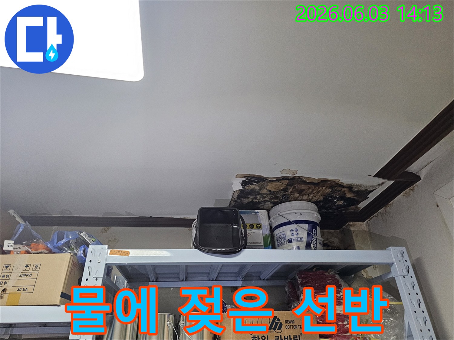 천장 누수로 인해-아래 선반과-주변 물건들이-물에 젖어있는-피해 현장