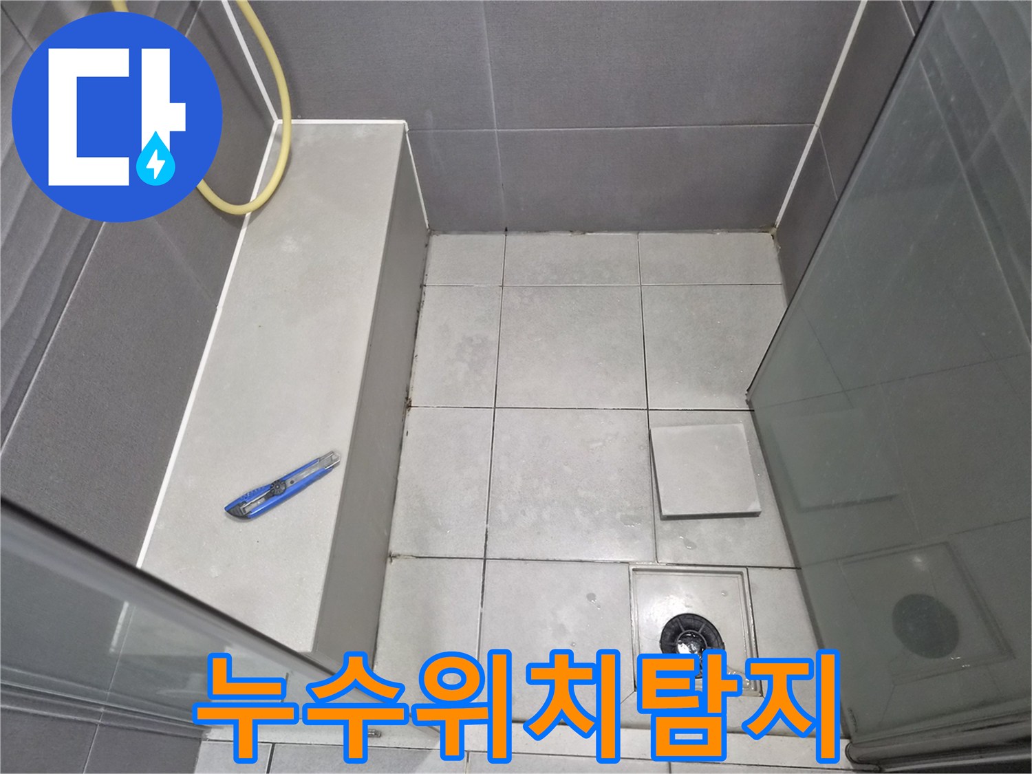 욕실-바닥-타일과-배수구-주변을-점검하며-누수-위치를-탐지하는-엔지니어의-작업-현장-사진입니다.