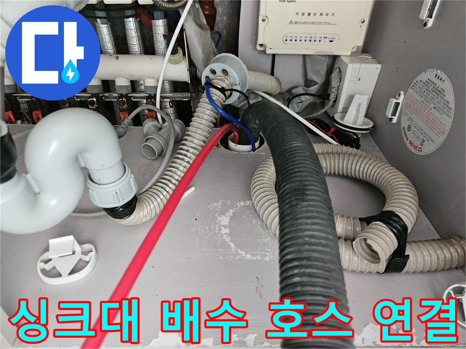 싱크대 하단 배수 호스와 굵은 배관이 만나는 지점의 상세 사진