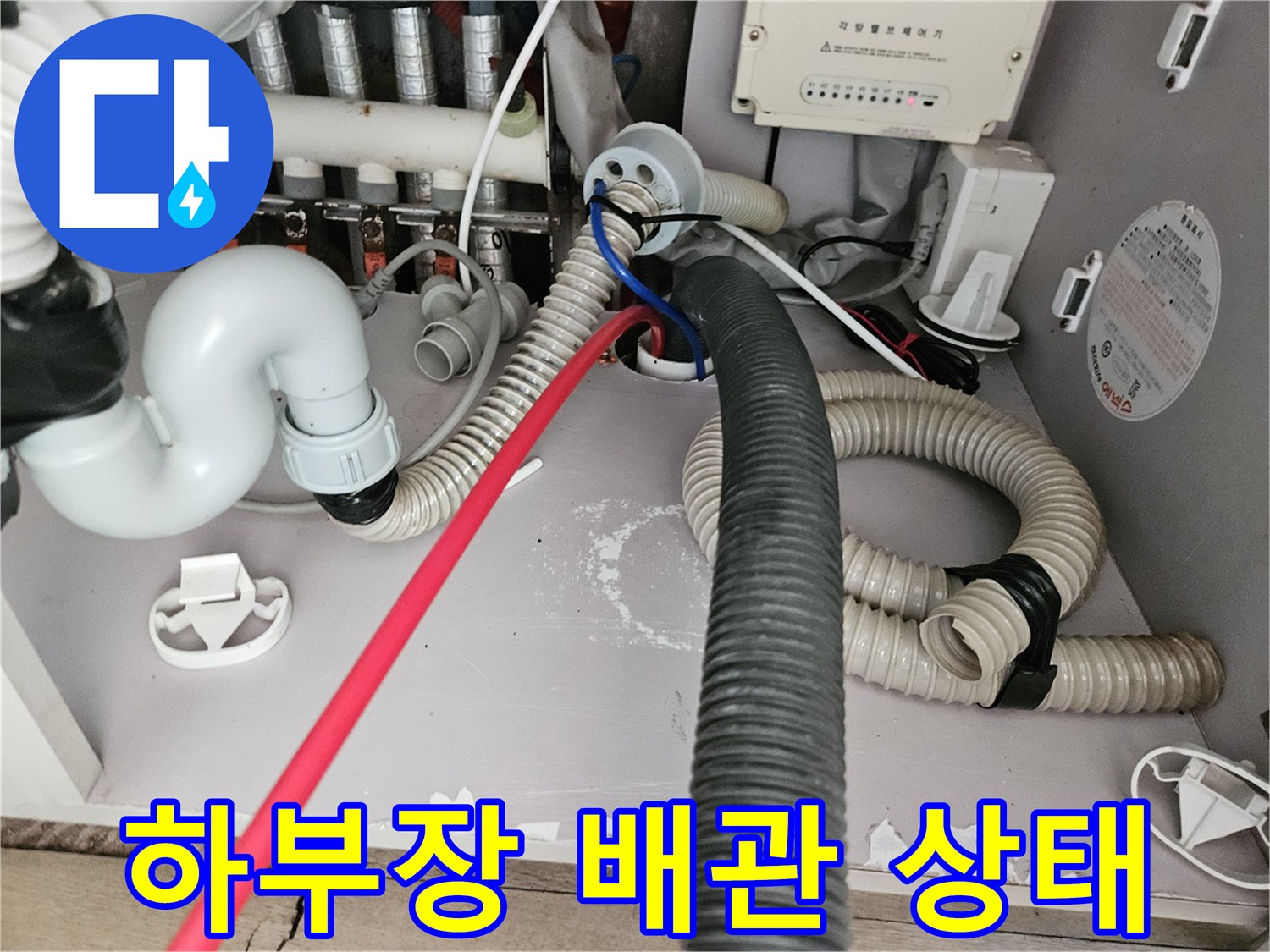 싱크대 하단 배수 호스와 연결된 굵은 주름관의 배치 모습