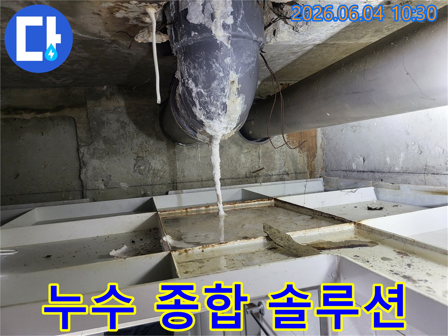 천장 배관에서 물이 새어 나와-석회질이 고드름처럼 맺히고-아래 바닥에 물이 고인 누수 현장