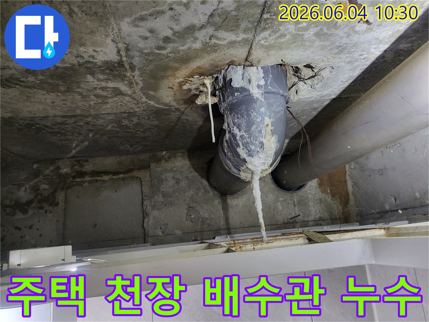 천장 콘크리트와 배수관 연결 부위에서-물이 새어 하얀 석회질이 길게 형성된 모습