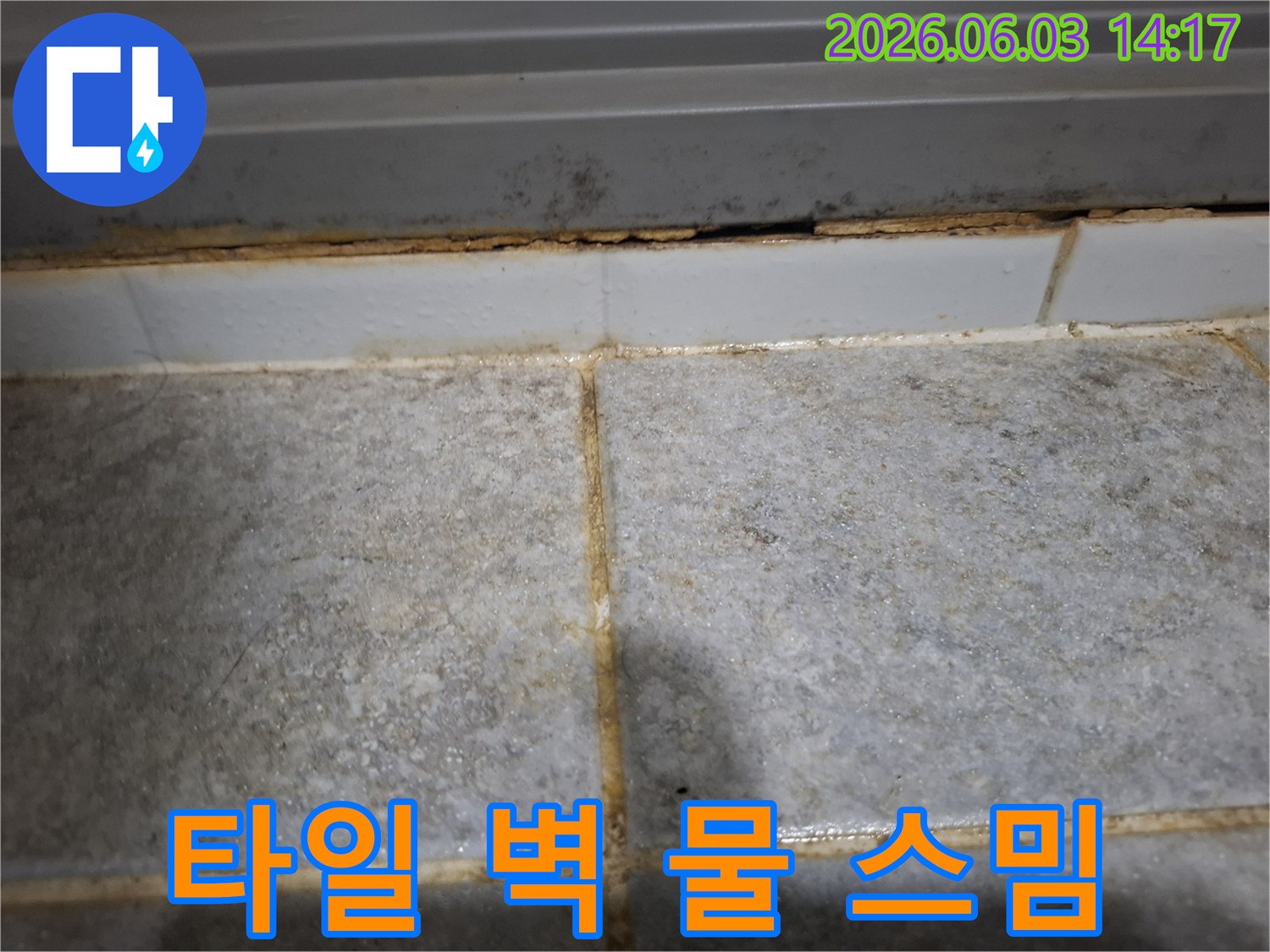 타일과 벽면 사이로 물이 스며들어-주변이 심하게 오염된 누수 현장을 담은 사진입니다