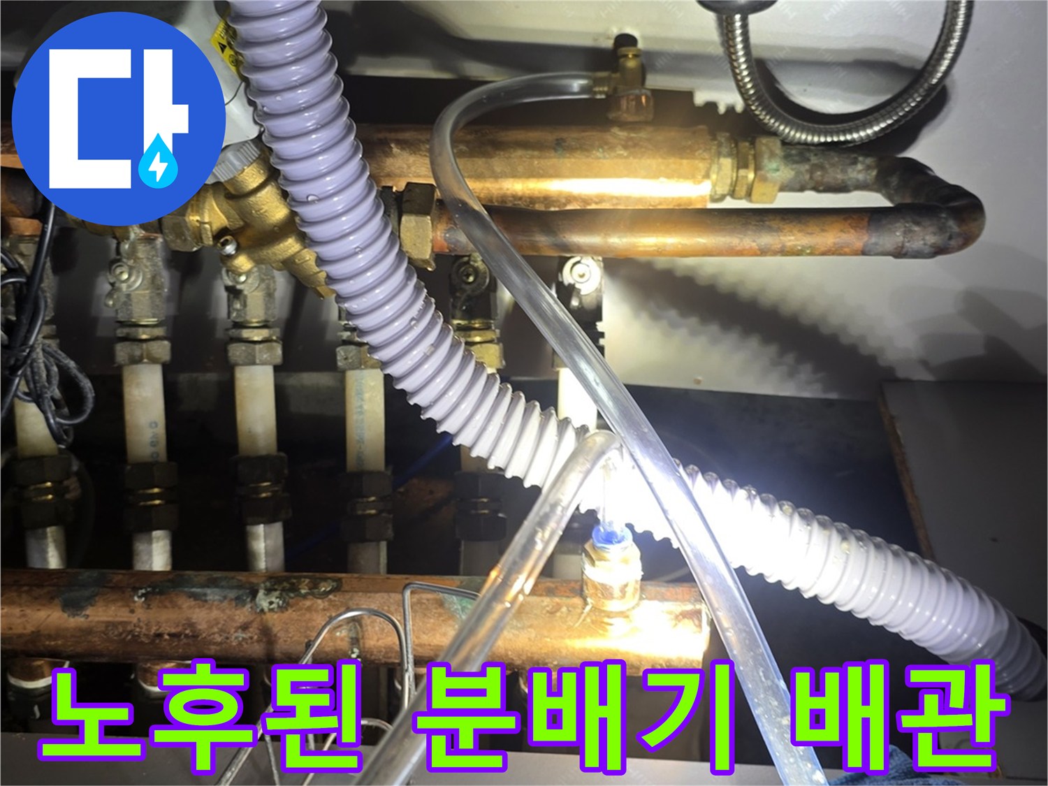 부식된 금속 배관과 투명 호스가 연결된 보일러 분배기 내부