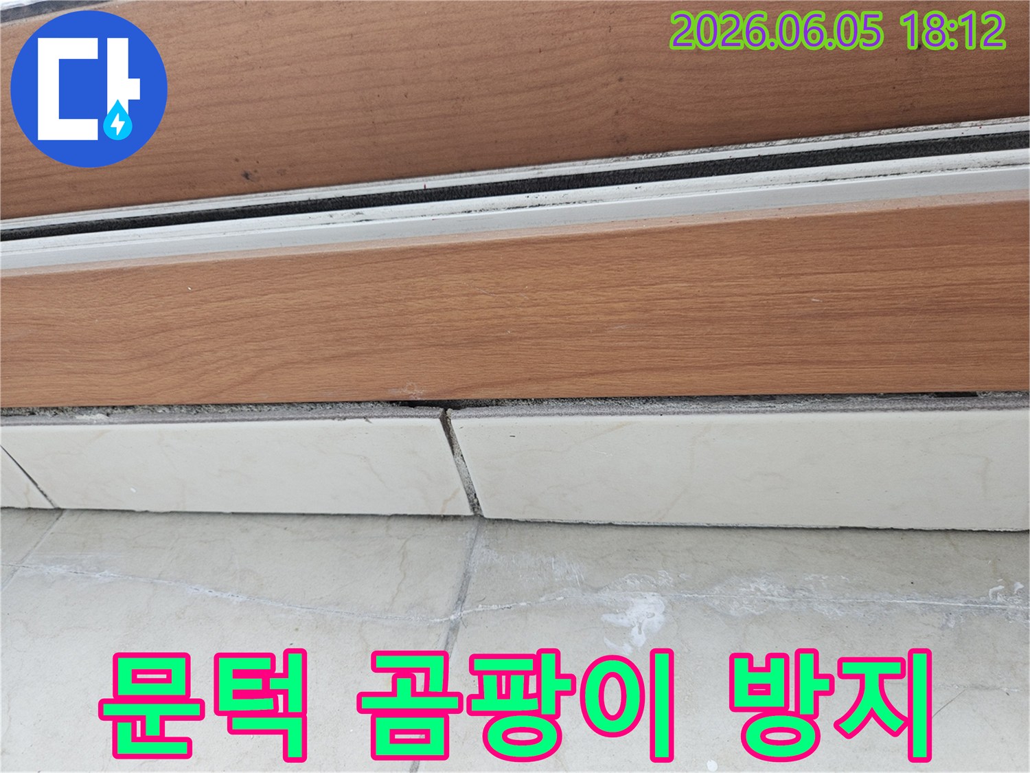문턱-하단과-타일-경계선에-보이는-물자국과-습기-흔적을-통해-곰팡이-발생을-방지하기-위한-계획을-세우는-모습