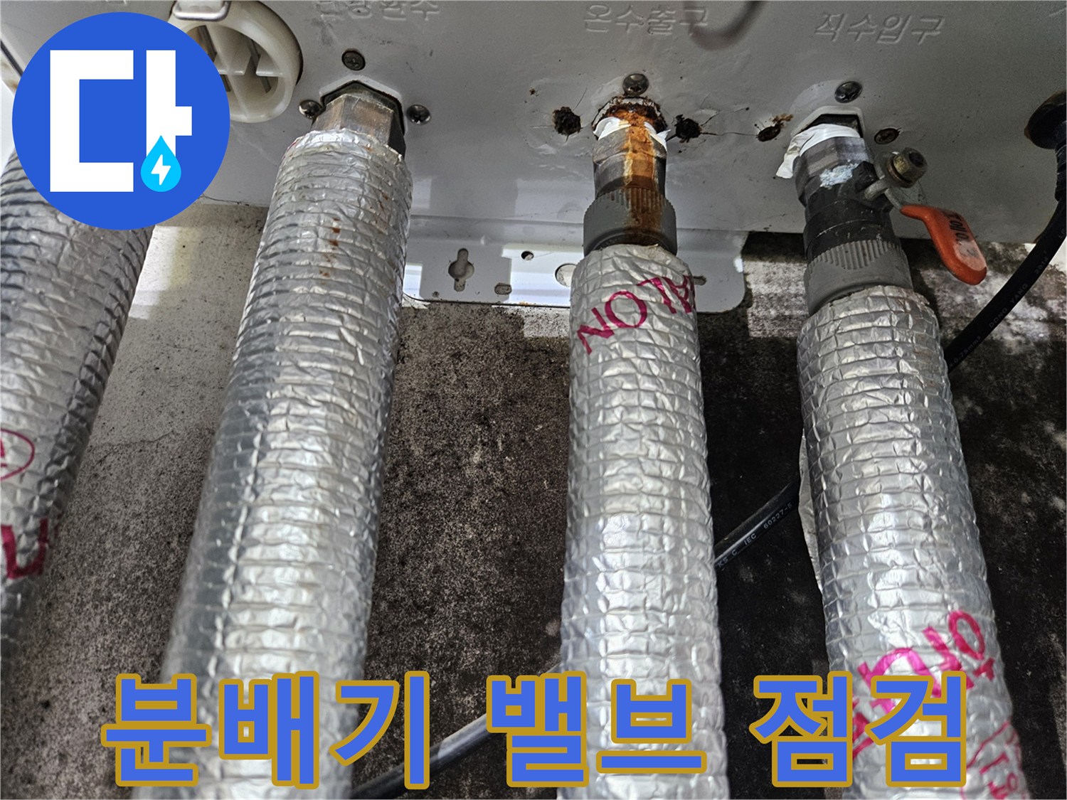 보일러 분배기의 금속 연결 부위와 보온재 상태를 보여줍니다.