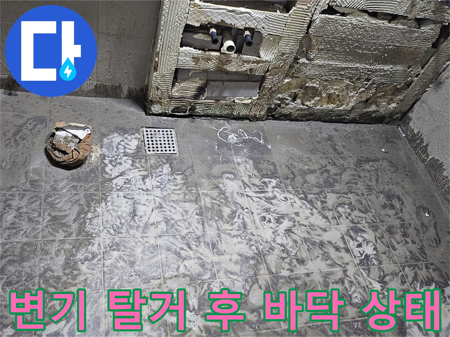 탈거된 변기 자리 주변의 젖은 타일과 배관 노출 부위
