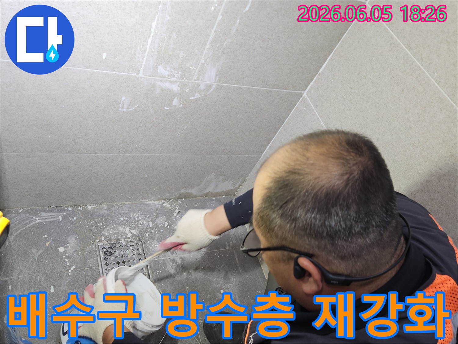 전문 기술자가 화장실 배수구 주변의 누수 취약점을 보완하기 위해-방수층을 재강화하는 작업을 꼼꼼히 진행하고 있습니다