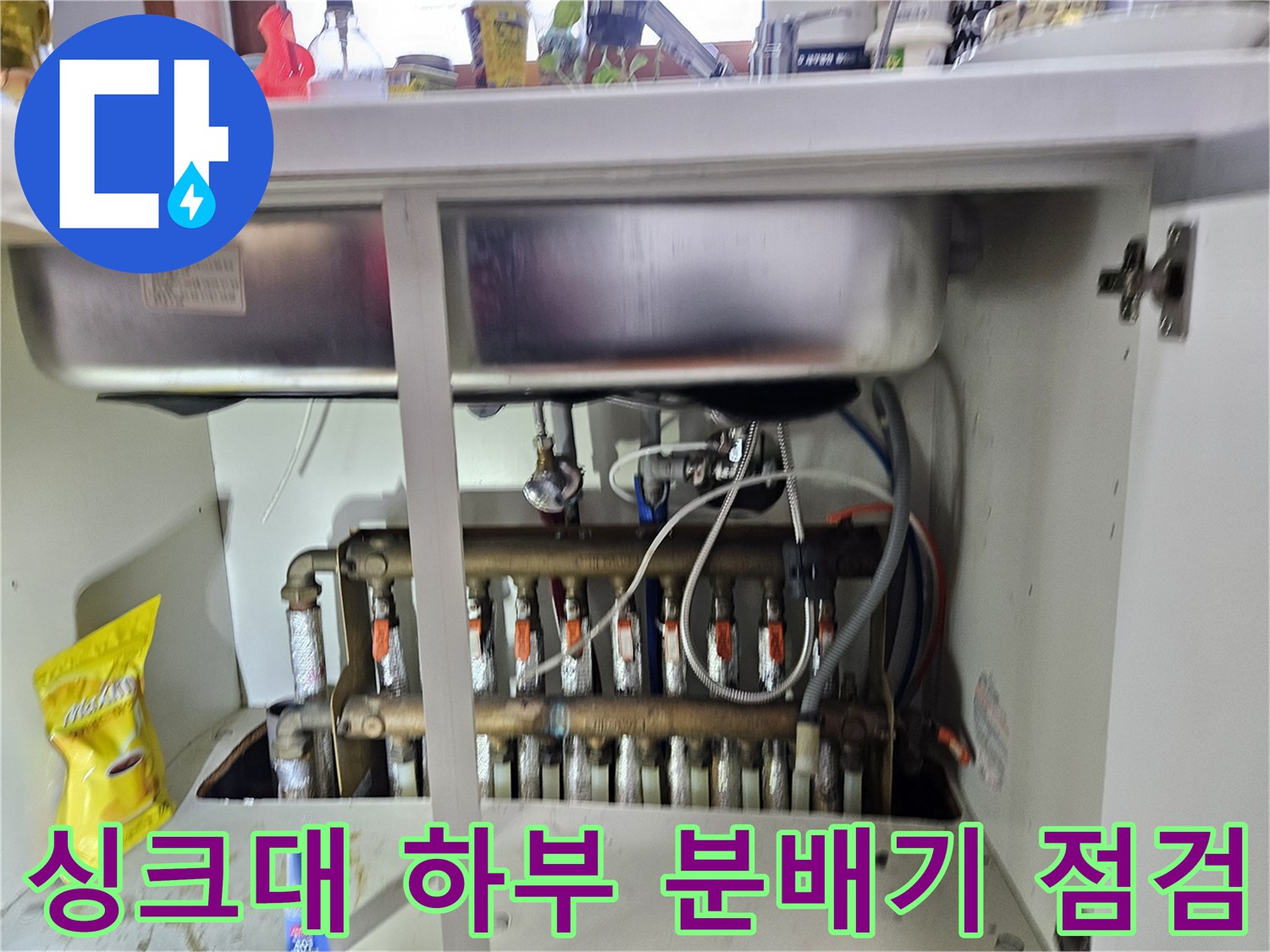 동대문구 전농동 아파트 싱크대 하부장 내부의 난방 분배기와 연결 배관 모습입니다.