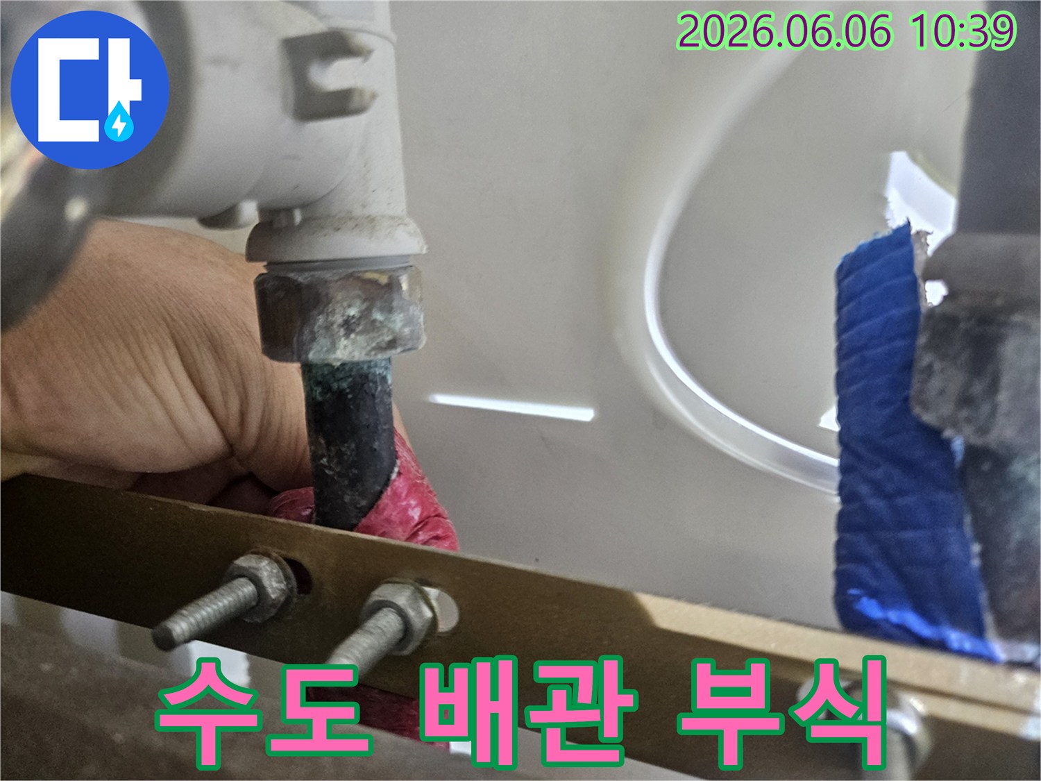 오래된 수도 배관의-부식된 연결 부위에서-물이 새는-현상을-전문가가-점검하고 있습니다