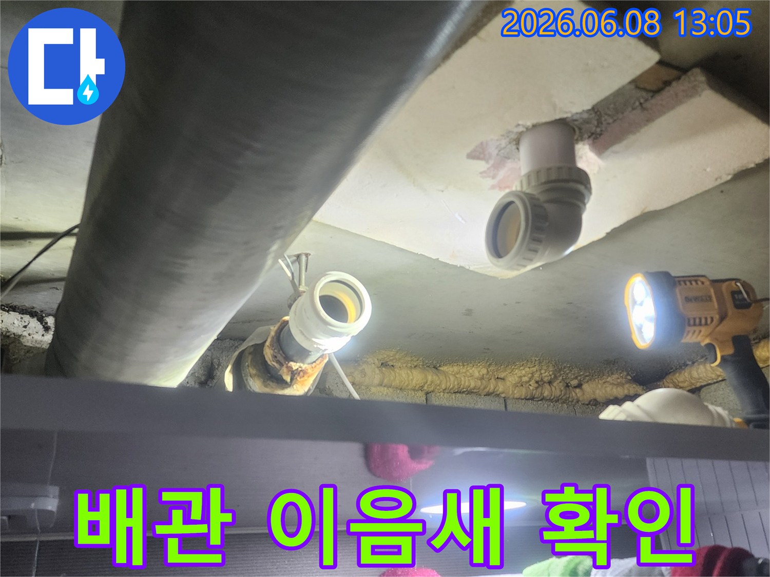 누수-전문가가-어두운-천장-속-배관의-이음새-부분을-집중적으로-확인하며-누수-여부를-판단하는-장면