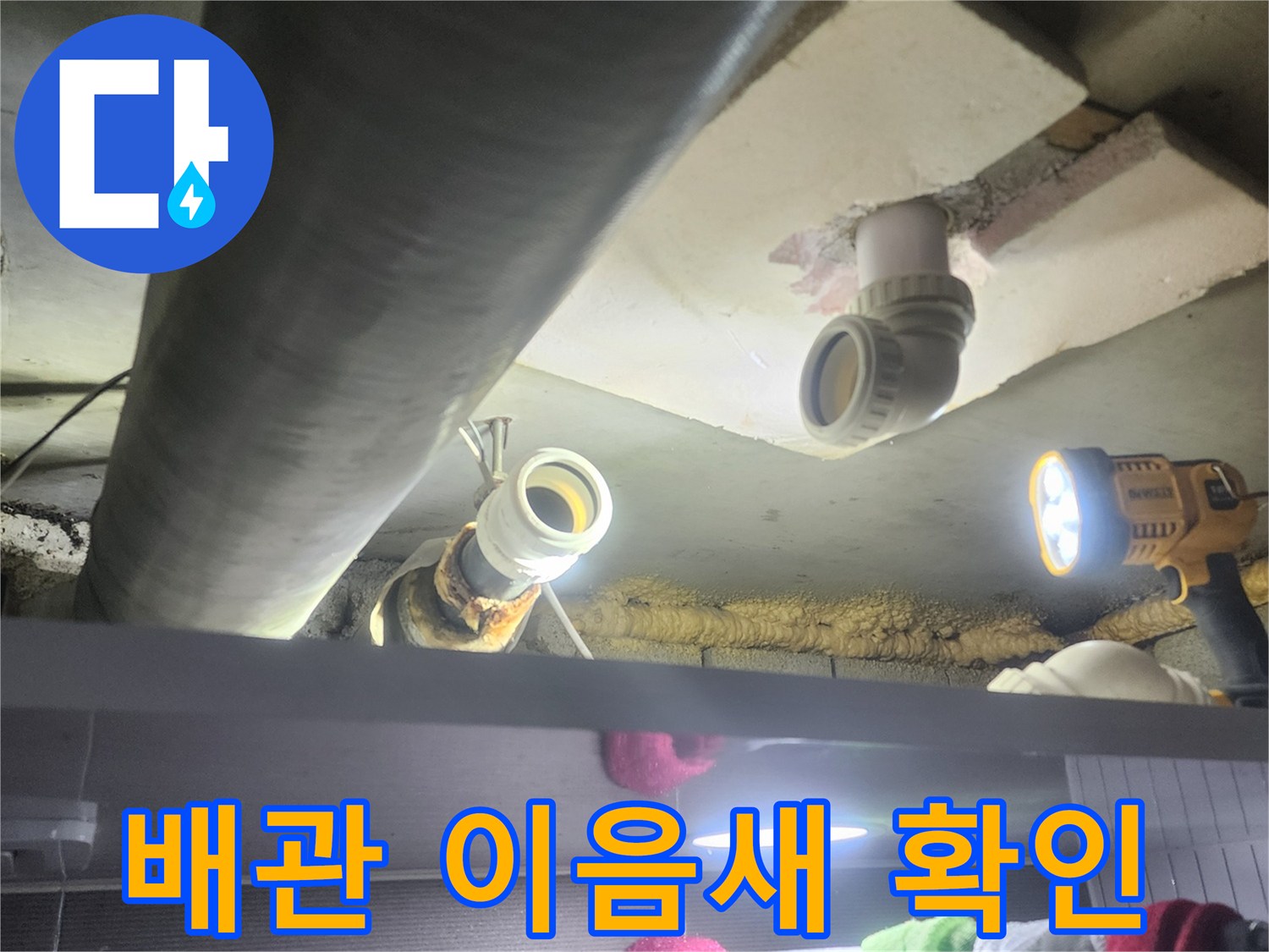 누수-전문가가-어두운-천장-속-배관의-이음새-부분을-집중적으로-확인하며-누수-여부를-판단하는-장면