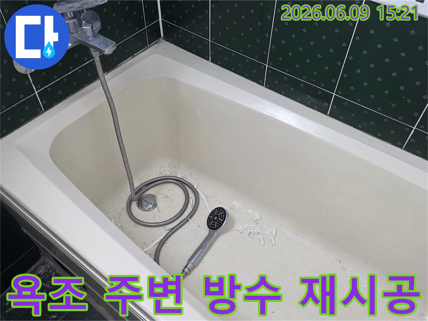욕조 내부 바닥에 하얀 이물질과 샤워기가 놓여있으며-욕실 누수 방수 재시공이 진행된 현장입니다.