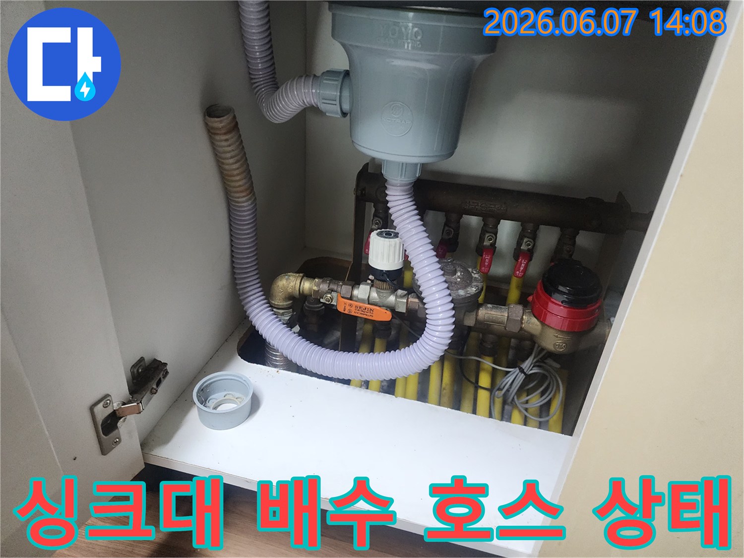 싱크대 하단에 연결된 회색 주름관과 밸브 구조물