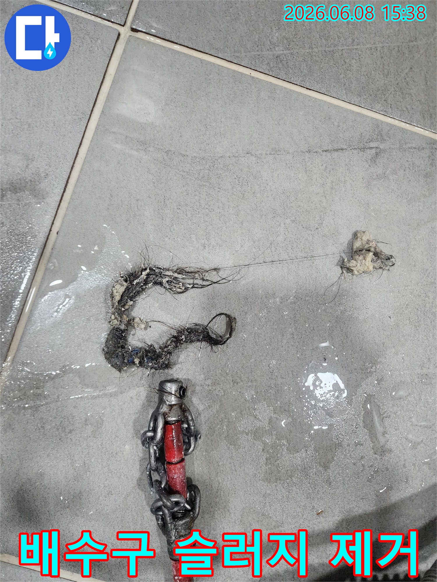 배관에서 긁어낸-검은색 슬러지와 석회 조각