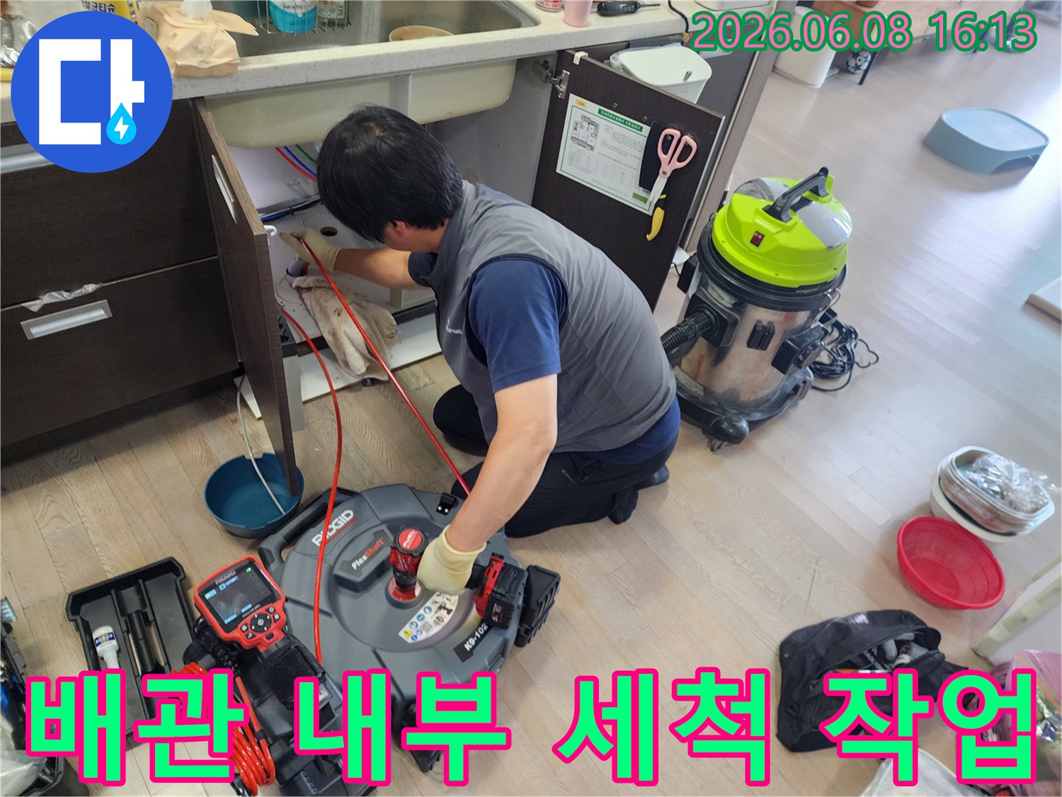 배관 스케일링 장비를 활용하여 싱크대 하부 배관을 청소하는 중입니다.