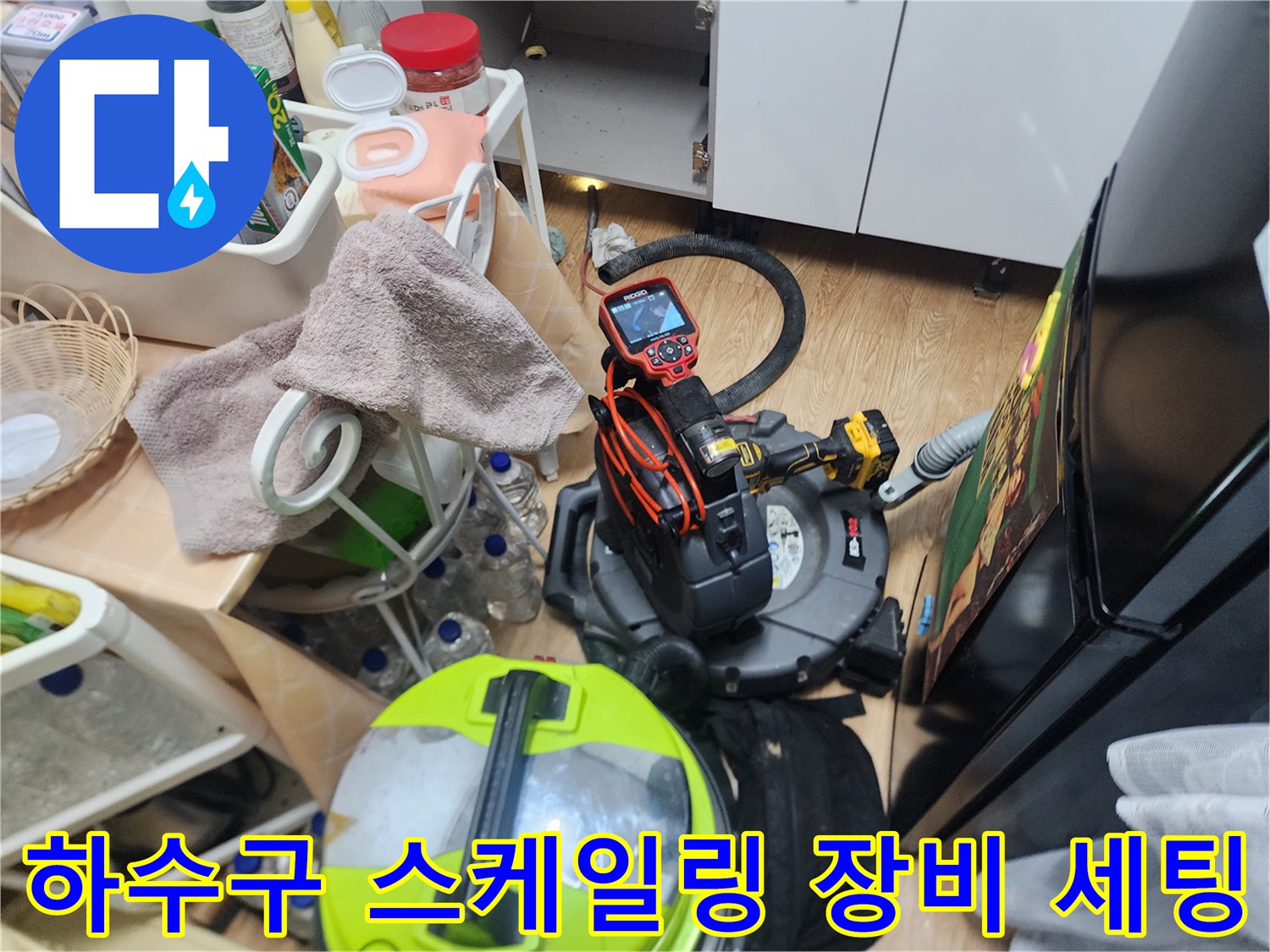 싱크대 아래쪽 공간에 배치된 배관 청소용 스케일링기와 전동 드릴