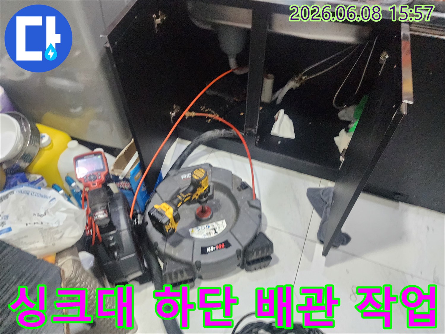 싱크대 아래쪽 공간에-배관 청소를 위해 배치된 전문 장비와 도구들입니다.