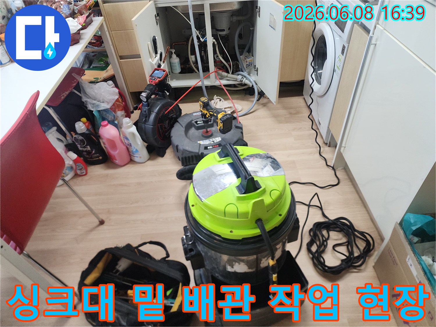 배관 스케일링 작업을 위해 싱크대 하부에 배치된 석션기와 도구들입니다.