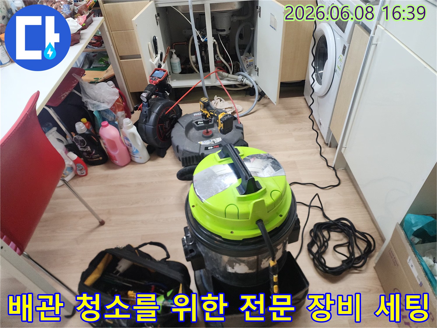 석션기와 배관 스케일링기를 싱크대 하부 배관 근처에 배치하여 작업을 준비합니다.