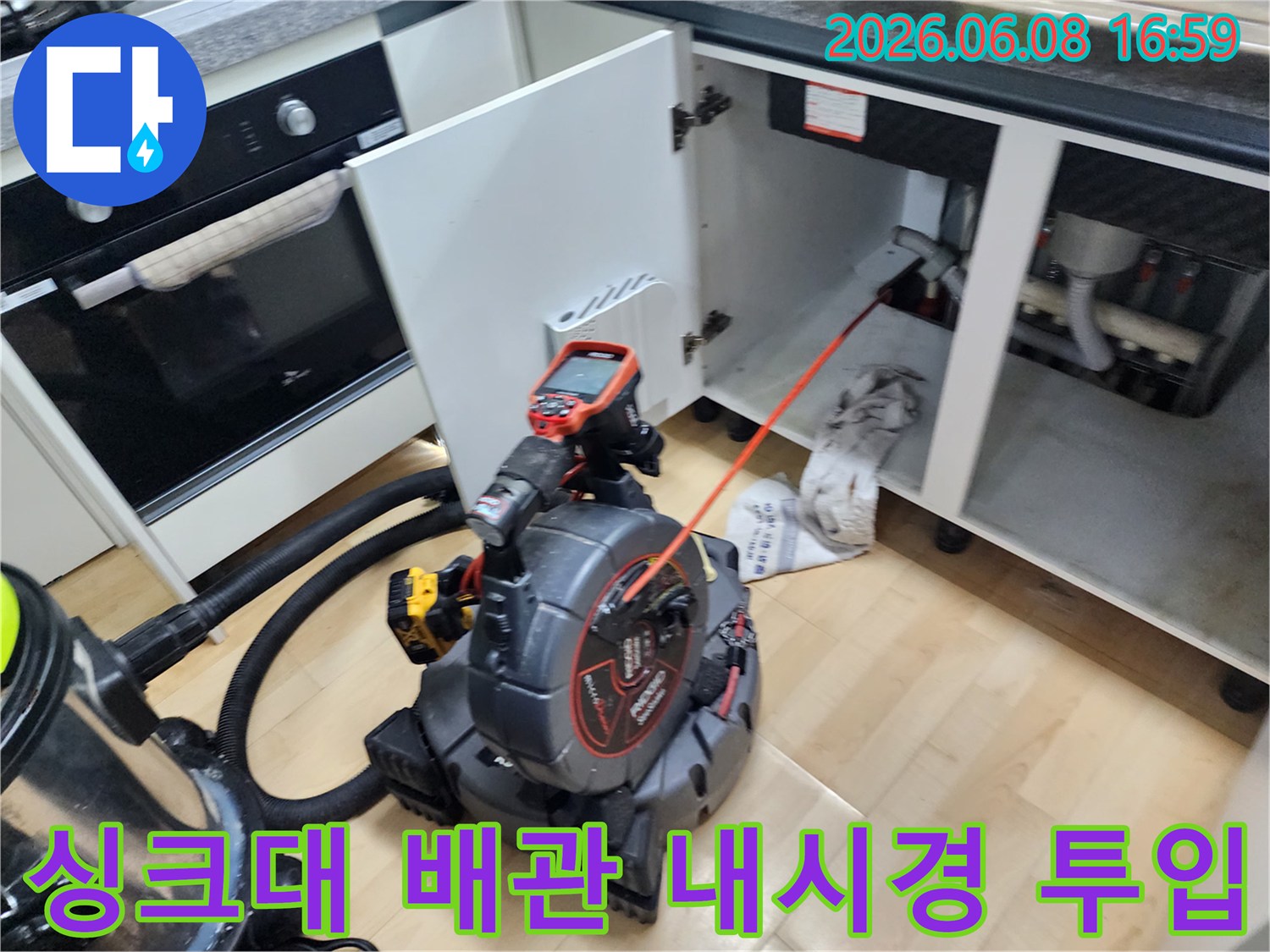 싱크대 하부장 배수관 내부의 기름 슬러지를 확인하기 위해 내시경 장비를 가동 중입니다.