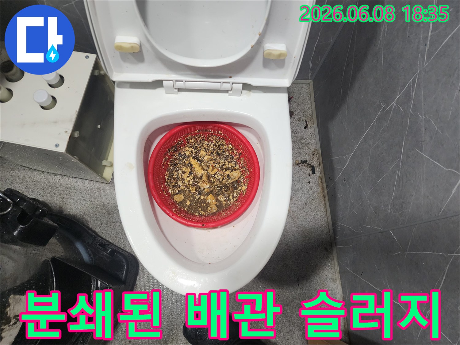 빨간색 거름망에 가득 쌓여 있는 배관 스케일링 작업 후의 오염 물질들