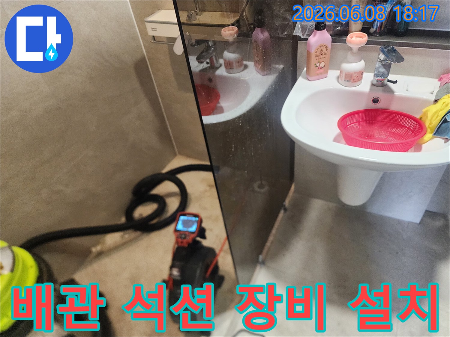 세면대 아래 배수구 막힘 해결을 위해 준비된 석션기와 배관 장비
