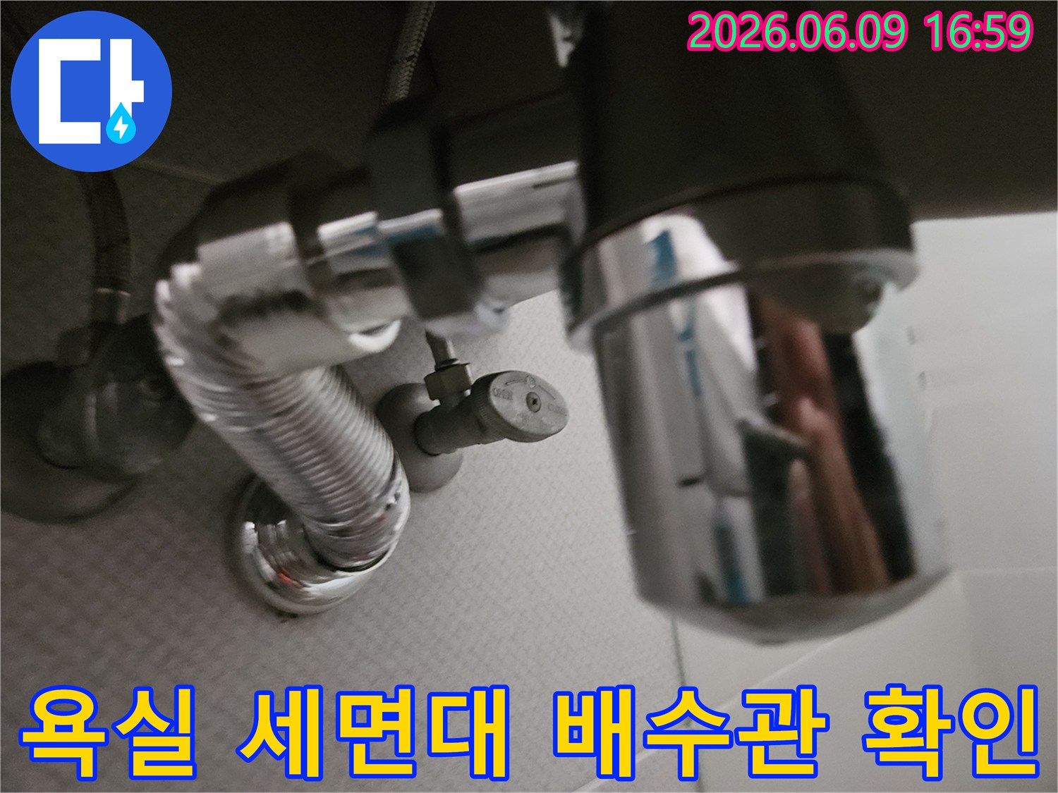 주방 싱크대 아래-복잡하게 연결된-배관 시스템과-수도 밸브의-모습을 담고 있습니다.