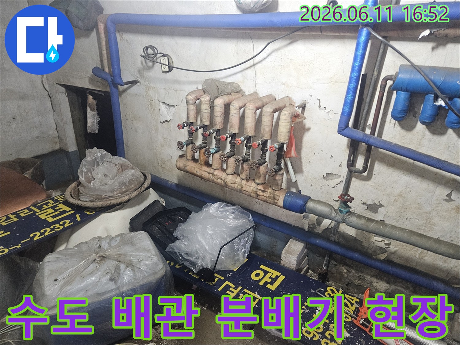 양주시-장흥면-누수-현장에서-수도-배관-분배기의-상태를-면밀히-살피는-모습을-촬영한-사진입니다
