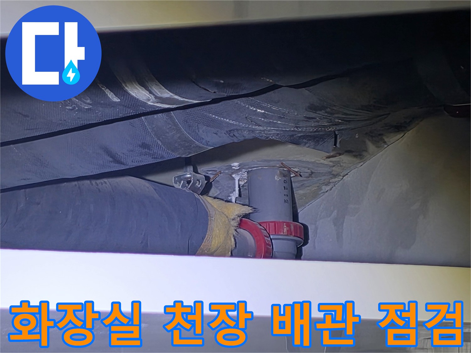 아파트 화장실 천장 내부-배관 연결 부위와 주변 슬래브의 습기 상태를 확인하는 모습
