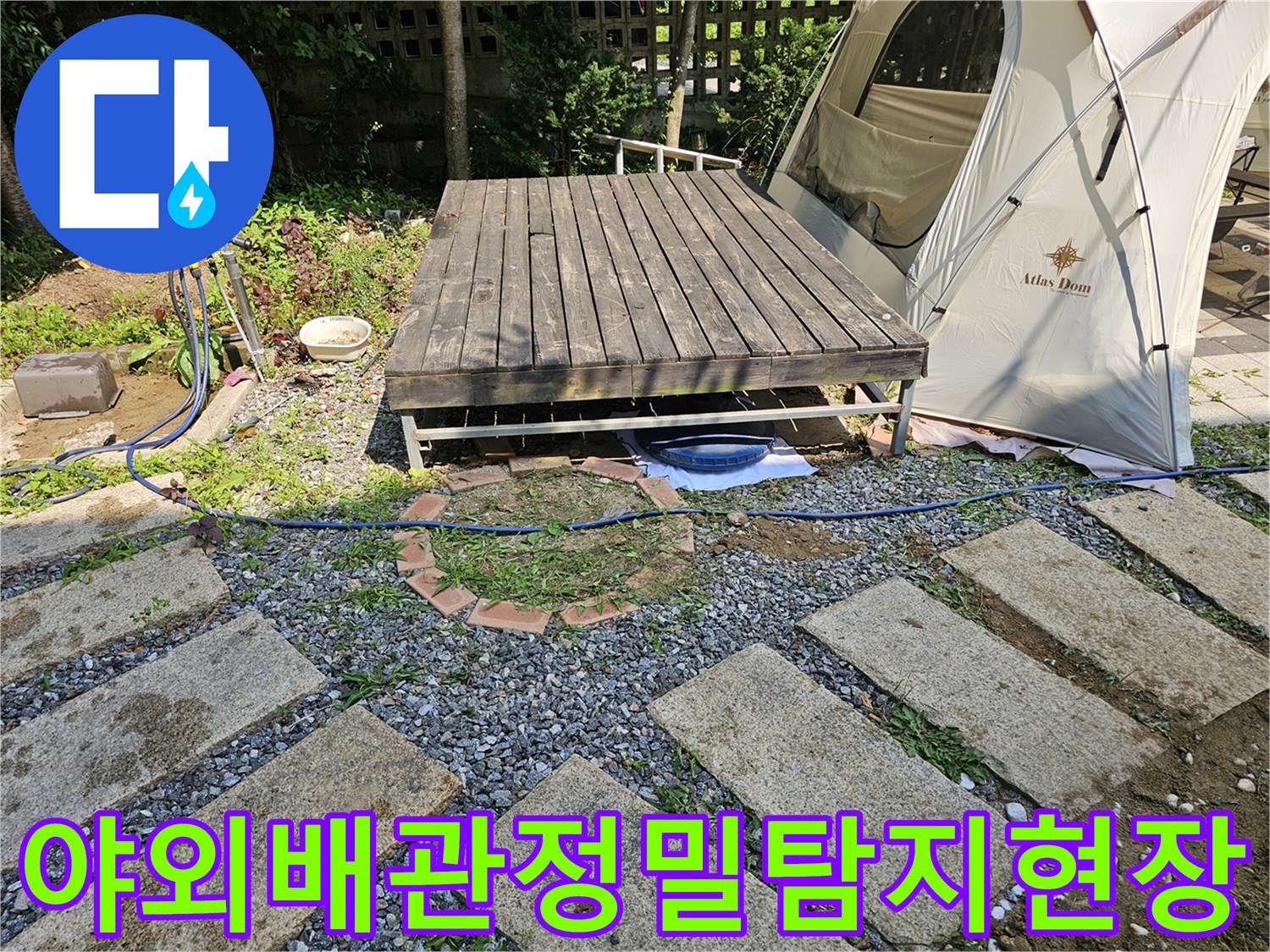 마당에 설치된 나무 데크 아래로 노출된 배관과 정밀 탐지 장비가 배치된 모습