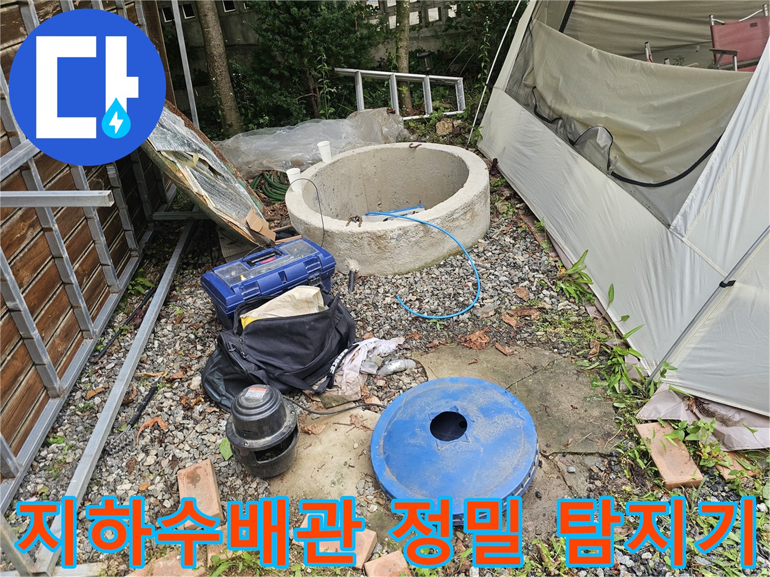 청색 배관 탐지 장비와 콘크리트 구조물 옆의 노출된 파이프