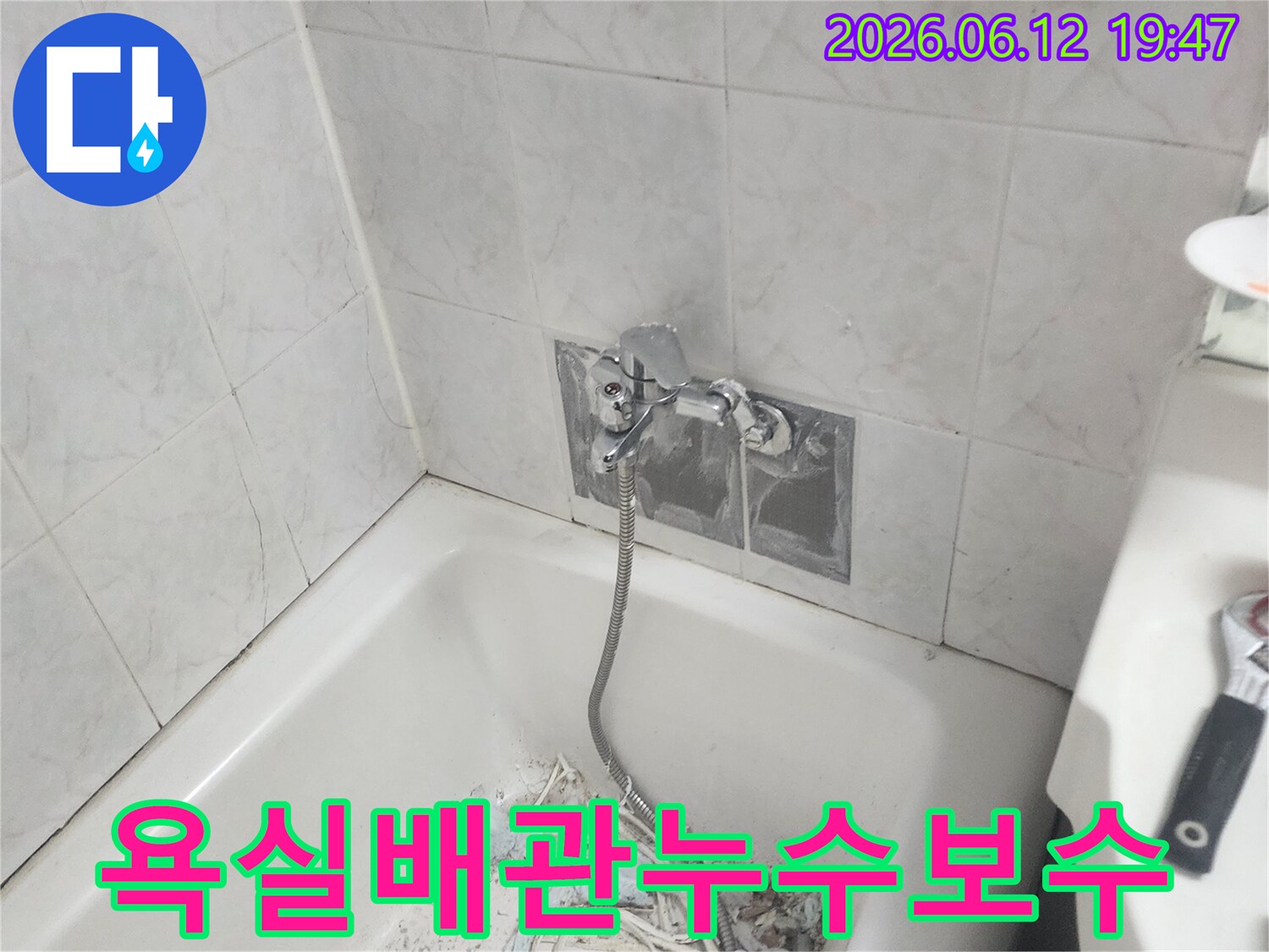 욕실 벽면 내부 배관에서 발생한 누수를 해결하기 위해 타일을 부분적으로 철거하고 배관을 보수하는 작업 현장 - 정밀한 기술이 필요합니다