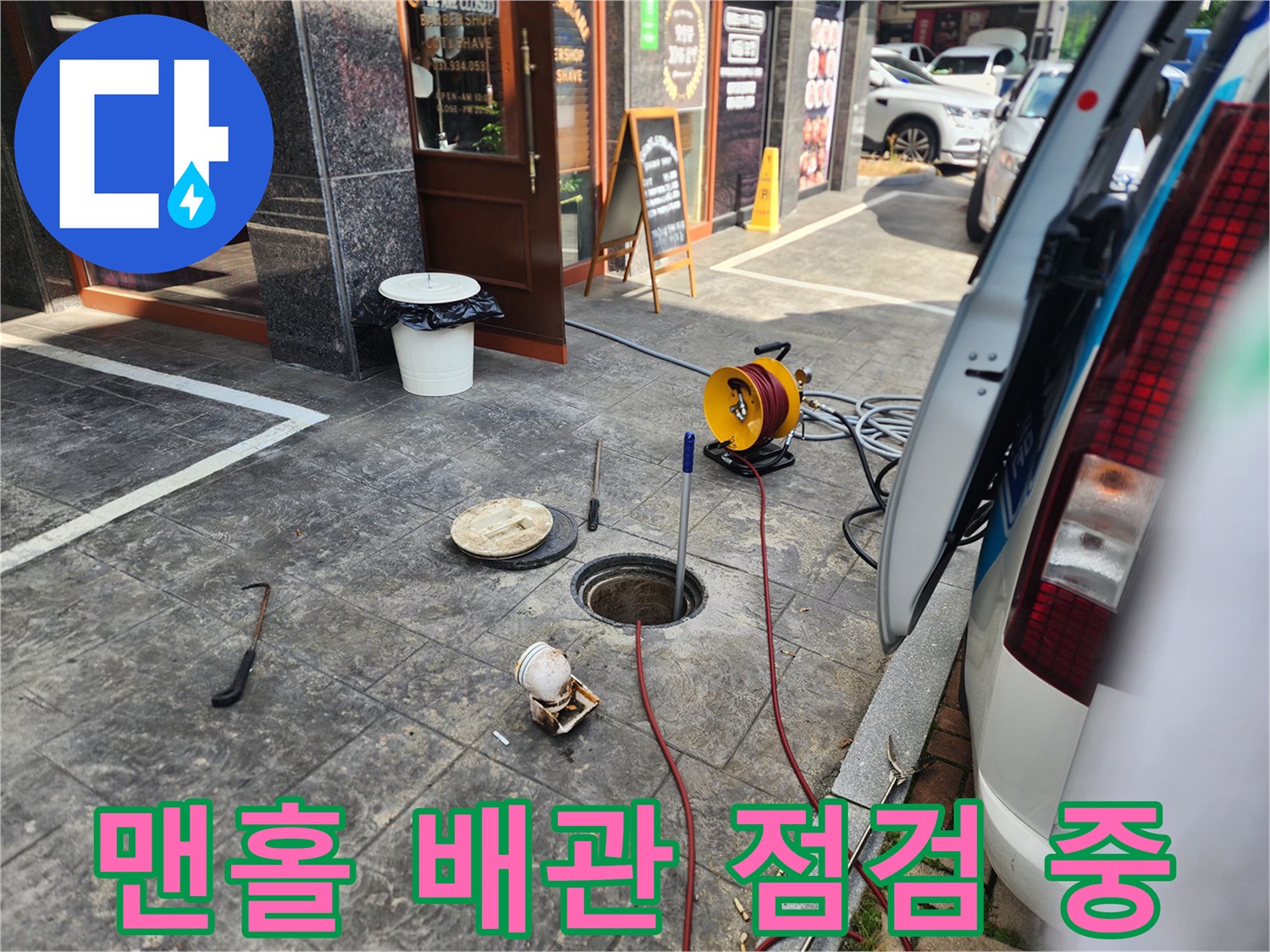 매장 외부 맨홀-열려 있는 배관 입구와 세척 호스 연결 상태