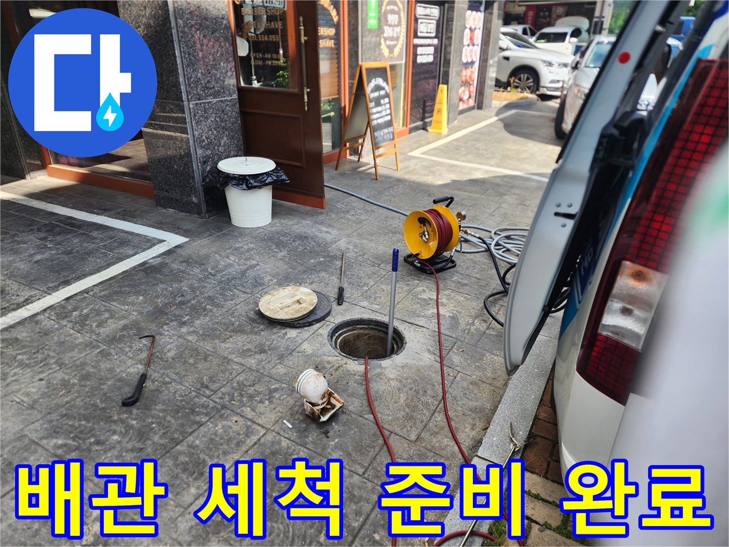 맨홀 입구에 고압 호스를 투입하여 작업을 진행하는 현장입니다.