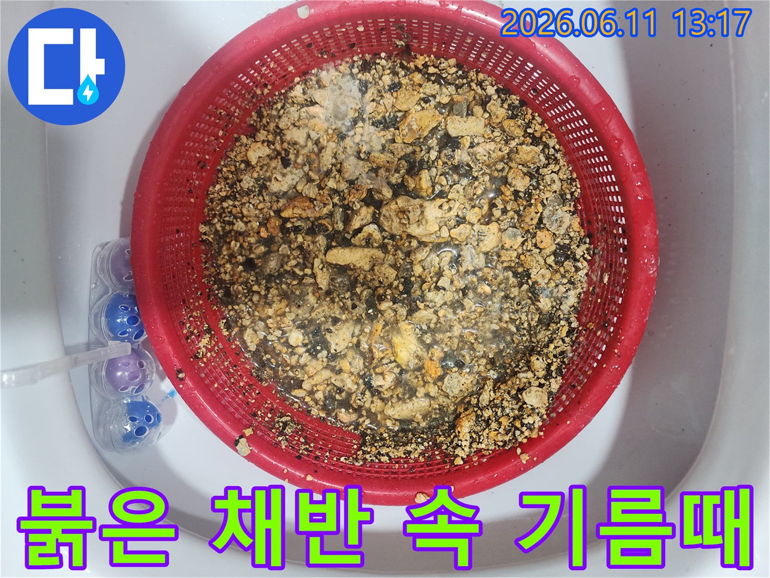 붉은색 거름망에 가득 쌓인 배관 내부 기름 슬러지 덩어리