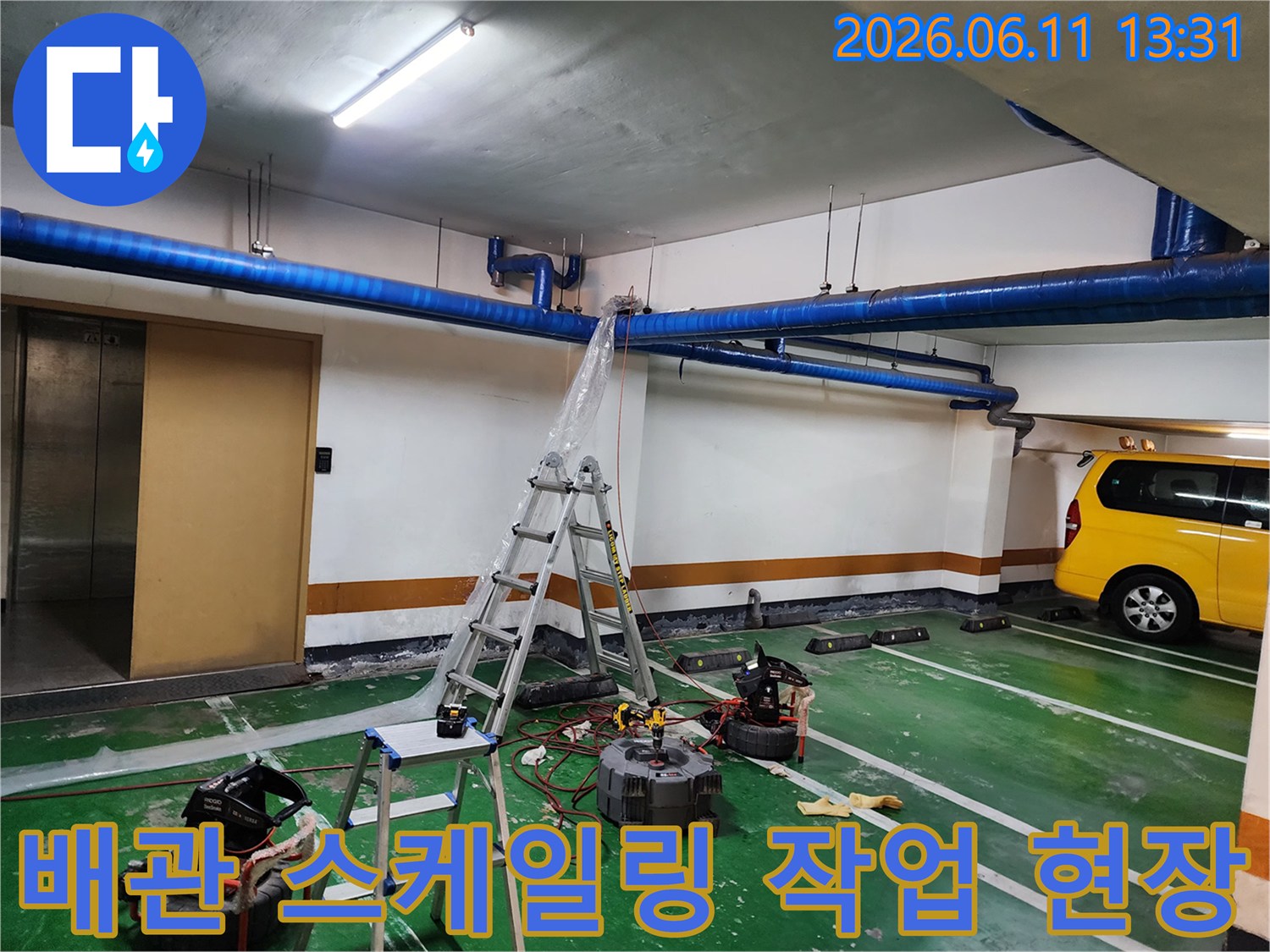 사다리에 올라가 천장 파란색 배관의 이물질을 제거하는 고압 세충 현장입니다.