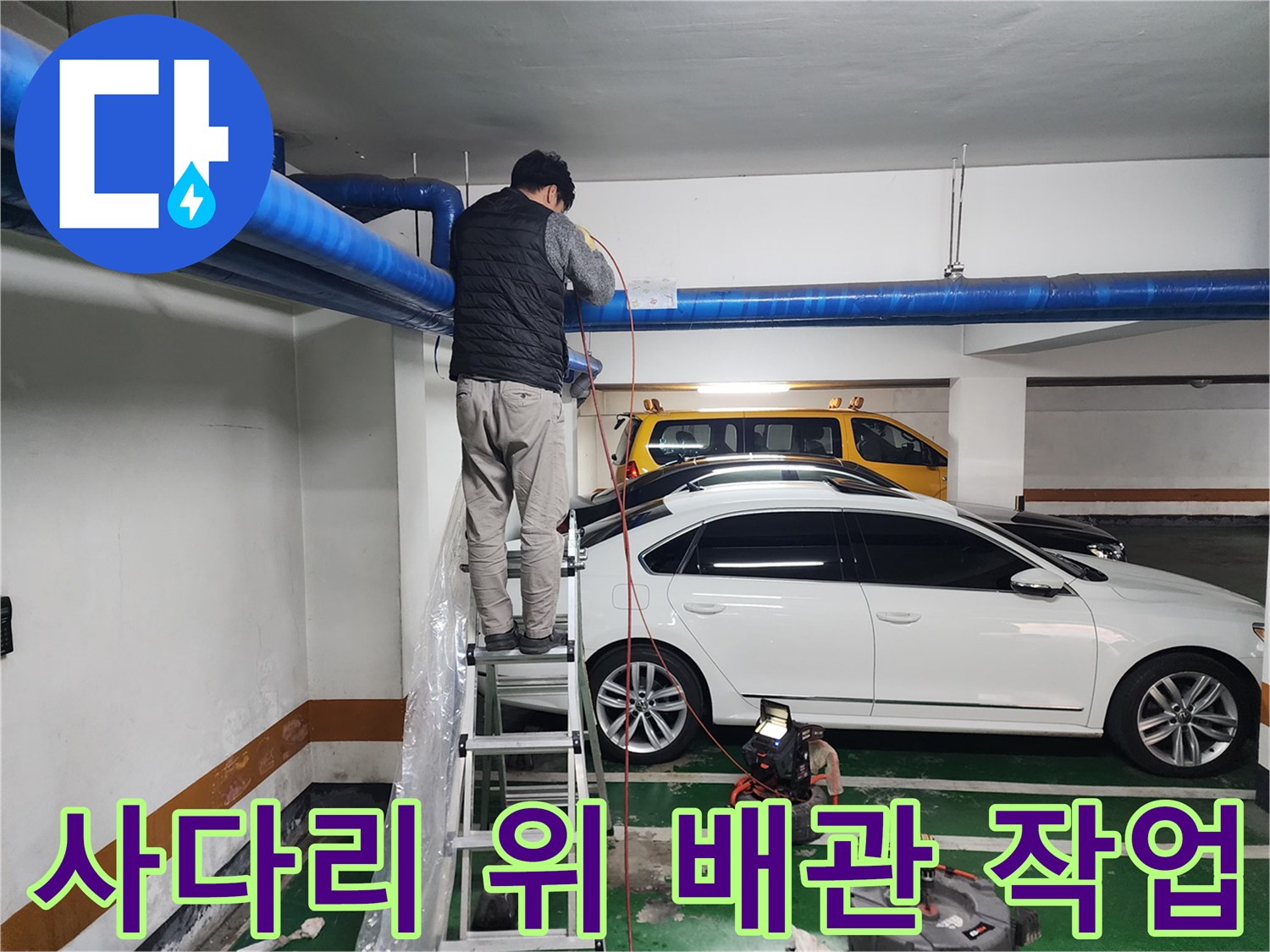 지하주차장 천장 파란색 배관을 점검하는 엔지니어의 모습