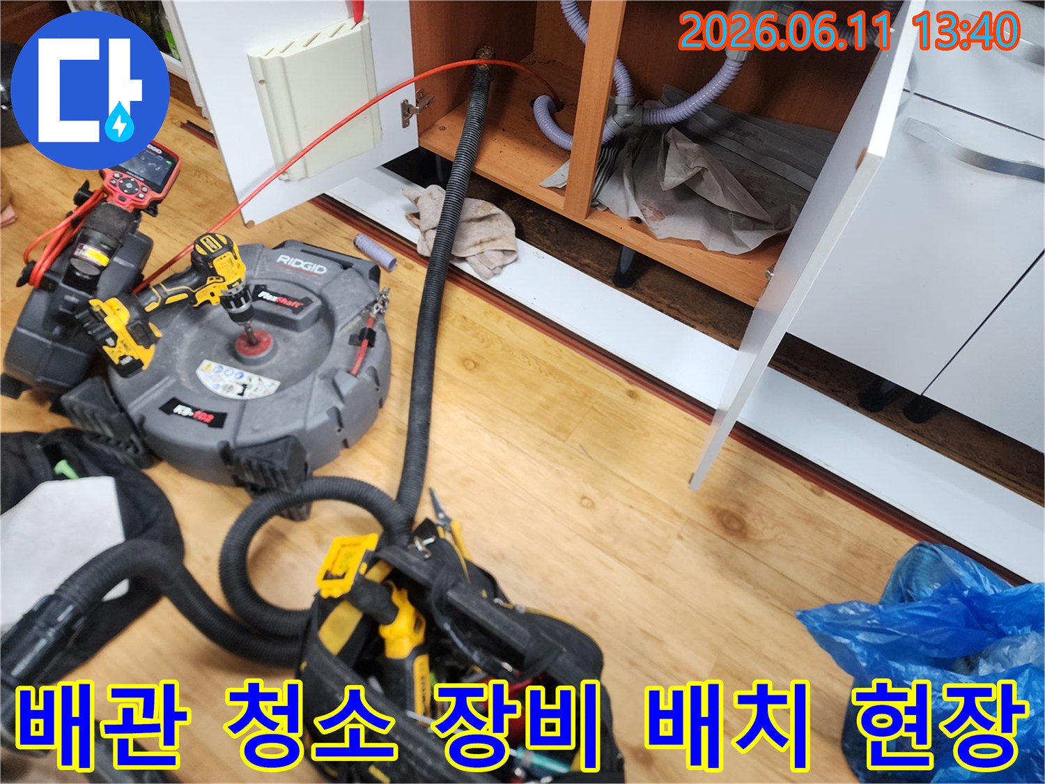 싱크대 하부 배관 작업에 사용될 전문 장비들이 놓여 있습니다.