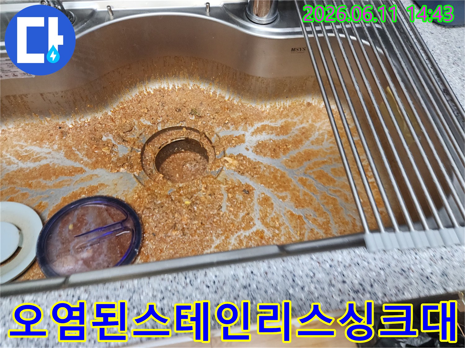 기름 찌꺼기가 배수구 주변에 넓게 퍼져 있는 싱크대 모습입니다.