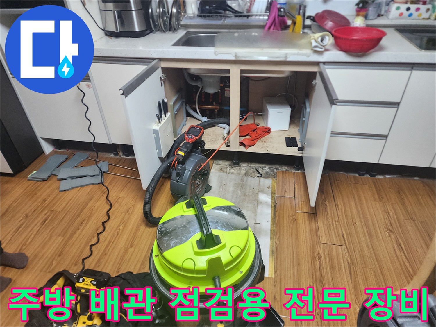 싱크대 하부장 내부의 막힌 배관을 확인하기 위해 준비된 석션기와 내시경 장비