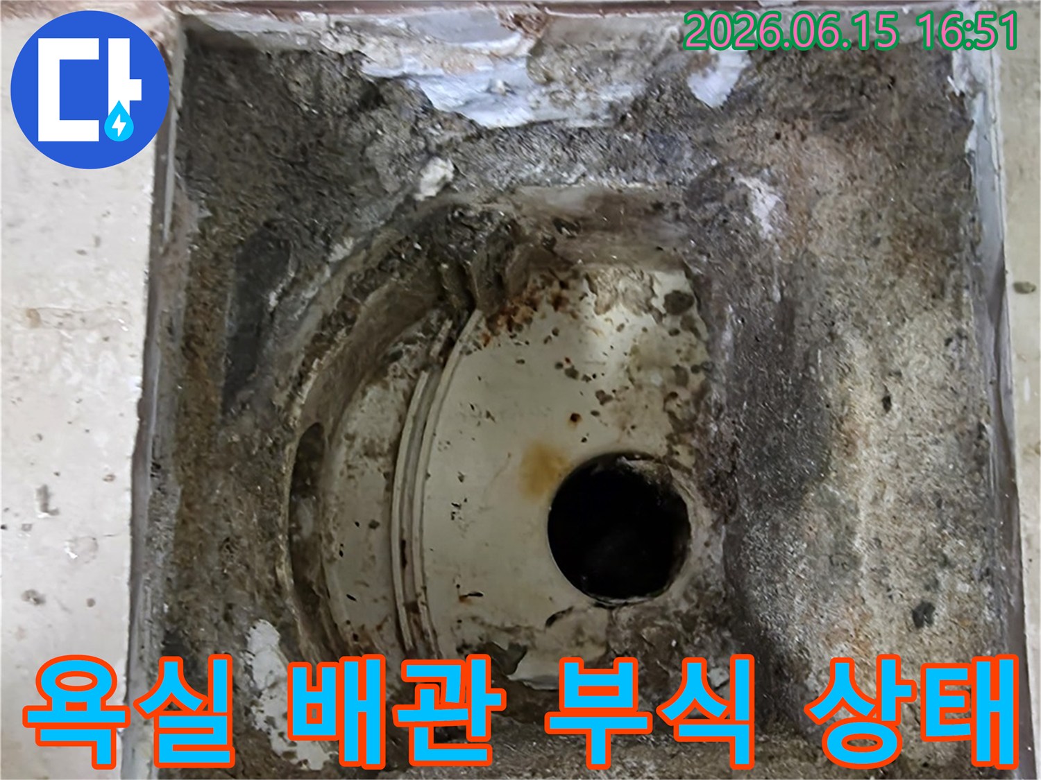안양 비산 삼성 래미안 아파트의-욕실 바닥에서 발견된-부식된 배관과 주변의 손상된 모습을 보여줍니다